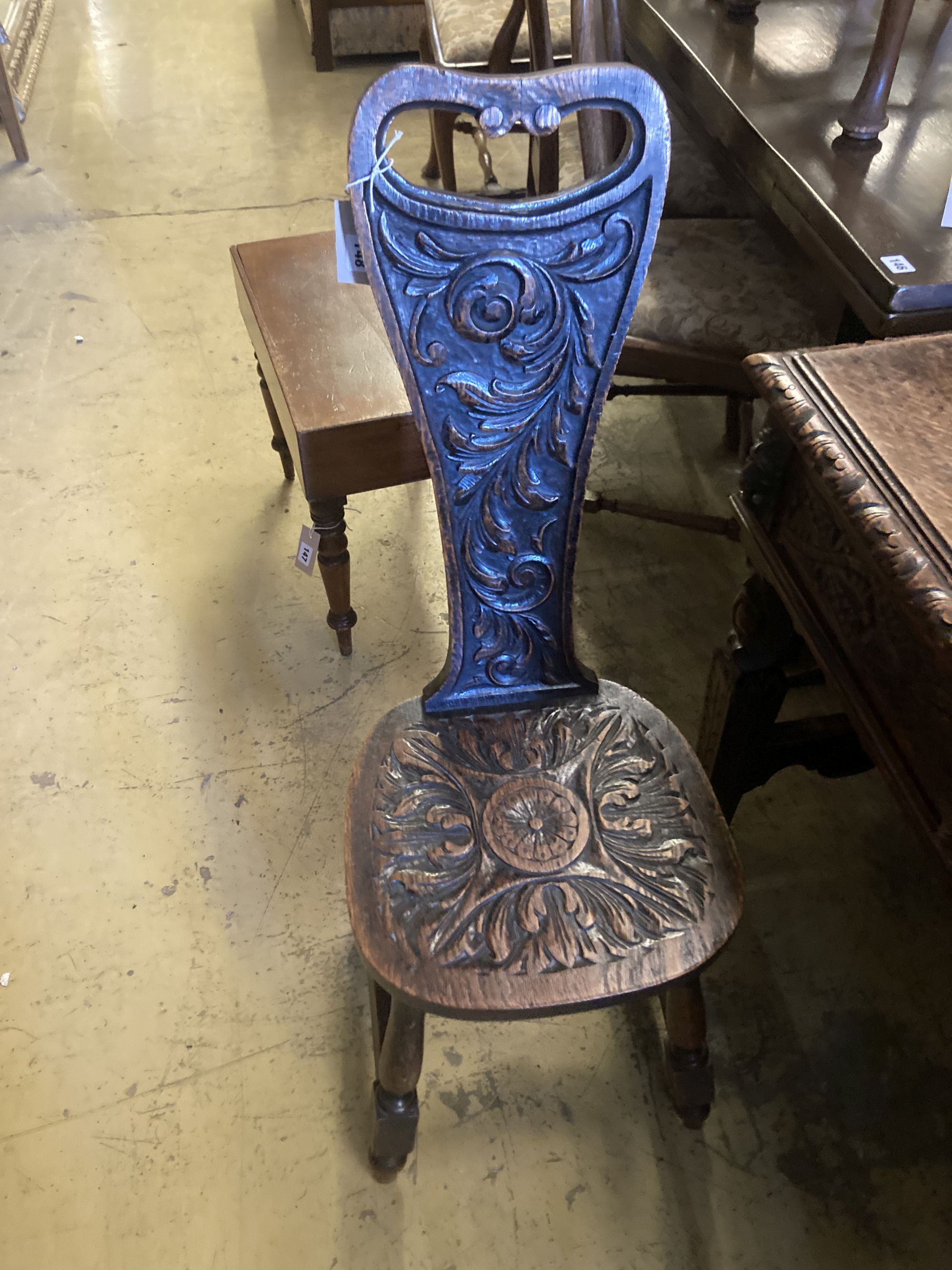 A late 19th century Flemish carved oak side table, width 88cm, depth 42cm, height 76cm, together with a carved oak spinning chair